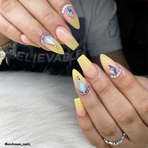Coffin and almond shaped Pastel Yellow Ombre nails adorned with rhinestones