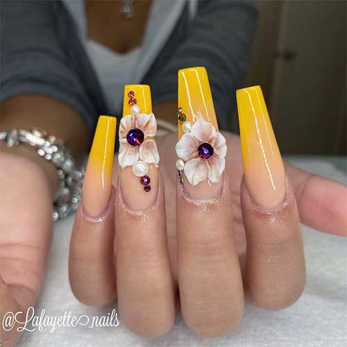 Coffin shaped yellow ombre nails with sunflower and rhinestones design Coffin shaped yellow ombre nails with sunflower and rhinestones design