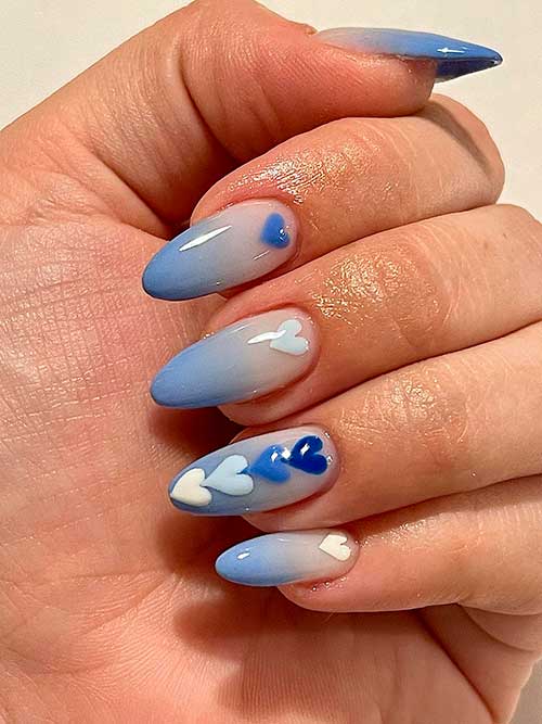 Blue Valentine’s Nails Long almond-shaped blue ombre valentine’s nails 2023 with white and different blue shades of hearts