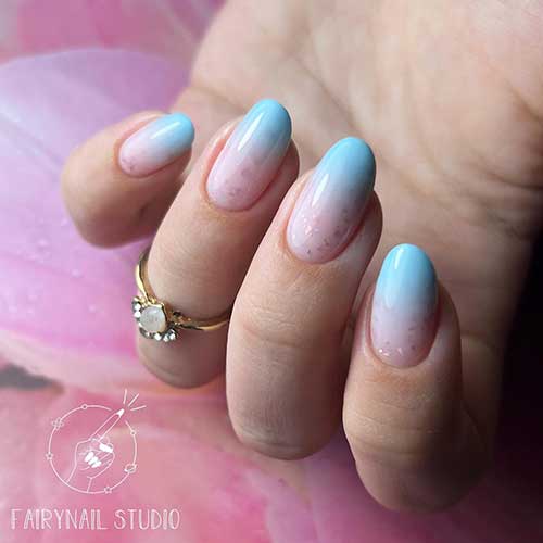 Medium round shaped baby blue ombre nails with glitter