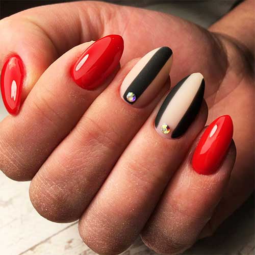 Cute short almond acrylic nails red with two accent matte black stripes on nude nails with a rhinestone
