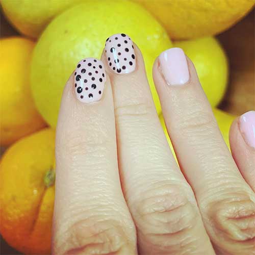 Cute short pink acrylic nails with two accent black polka dot nail art