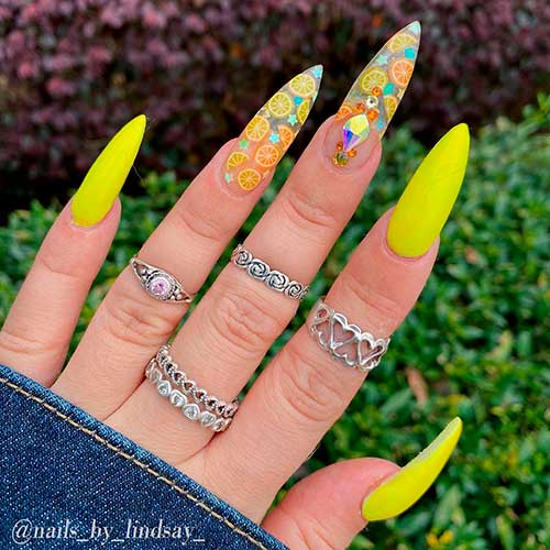 Cute neon yellow nails stiletto shaped with two accent lemon nails over clear acrylic nails!