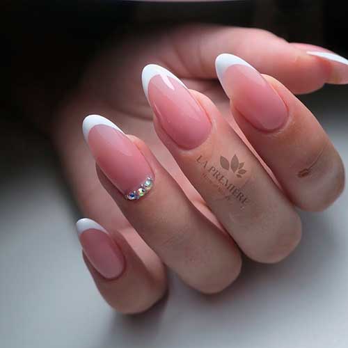 Gorgeous white almond French nails 2020 with rhinestones on accent nail design!