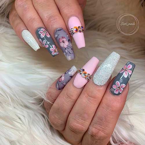Different grey nail shades between glitter, light, and dark floral grey nails with accent matte pink nail with rhinestones!
