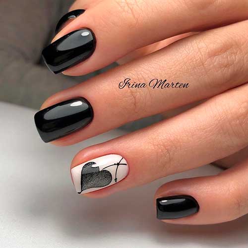 Glossy short black nails with black heart shaped on accent white nail! Glossy short black nails with black heart shaped on accent white nail!