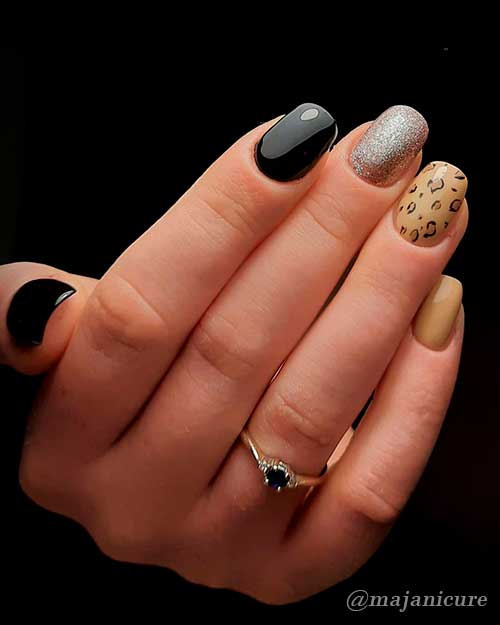 Glossy short black nails with silver glitter on accent nail and nude color leopard print nails!