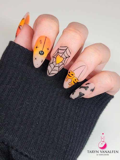 Nude Halloween nails almond shape that features spider webs, pumpkins, bones, spiders, and two orange ombre accent nails