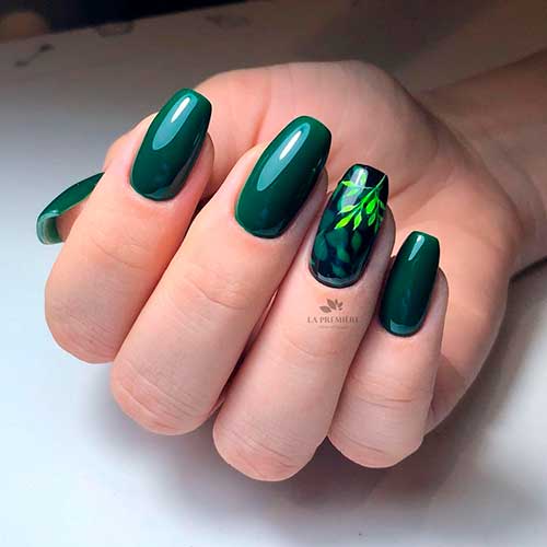 Cute dark green nails coffin shaped with a leaf nail art on accent nail!