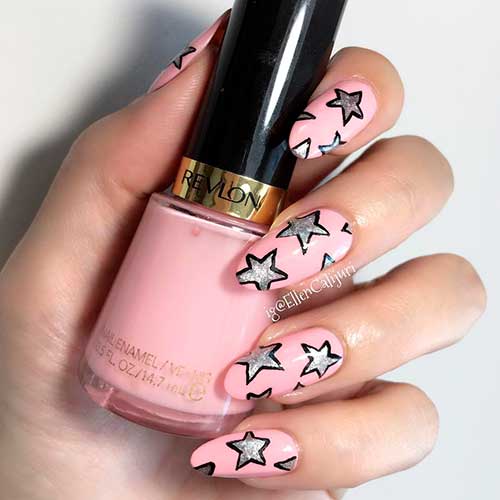 Top nails manicured with Revlon Coy super lustrous nail enamel nail polish on almond nail tips with silver glitter stars