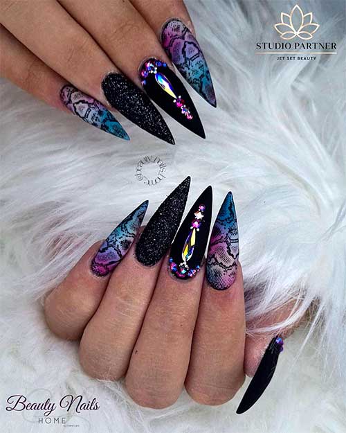 Cute stiletto snakeskin print nails 2020 with two accent black nails adorned with black glitter and rhinestones!
