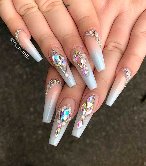 Cute bling nails 2020 that consists of blue grey ombre coffin nails with Swarovski crystals and the small rhinestones Design!