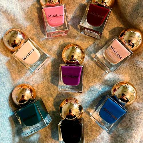 An array of Miniluxe nail polish bottles featuring an assortment of colors perfect for elegant nail designs.