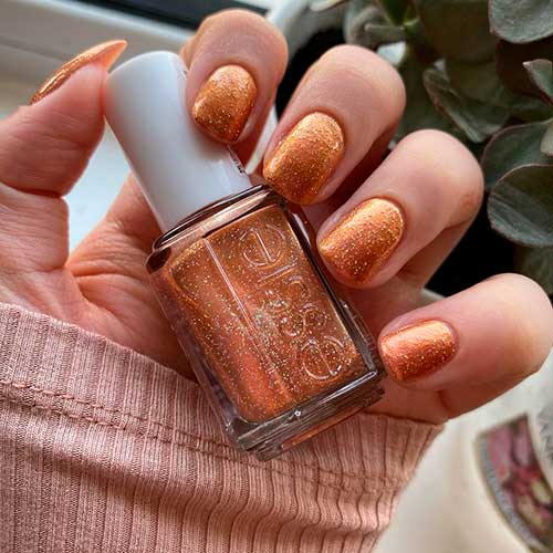 Wear cute autumn nails with sequin scene burnt orange nail polish from Essie Fall 2020 Roll with It Collection