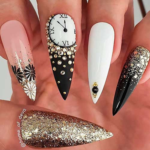 New year nails consist of black stiletto nails with gold glitter, two accent new year fireworks, and new year's clock nails