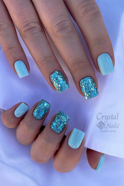 Square shaped short light blue nails with glitter light blue on two accent nails Square shaped short light blue nails with glitter light blue on two accent nails