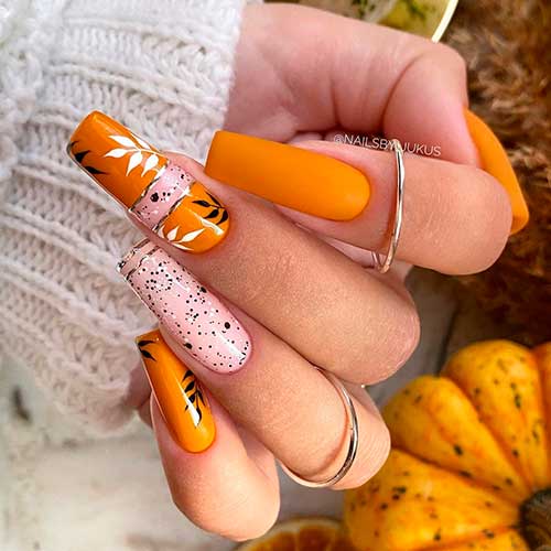 Long square burnt orange fall nails adorned with fall leaves and gold strips