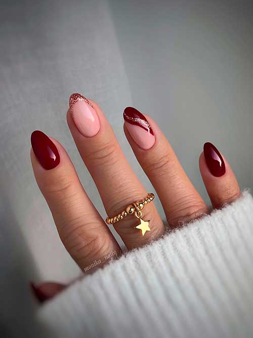 Short almond shaped wine red nails with gold glitter on French accent nails for the winter season