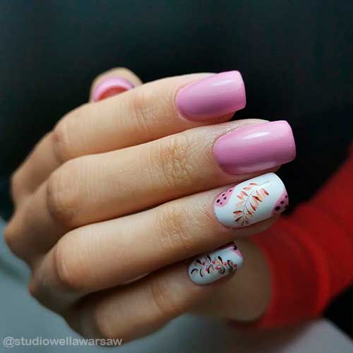 Square short pink nails with some fall leaves and black dots on accents with white nail base