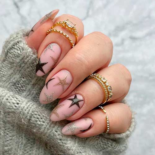 Party Vibe Glittery New Years Eve Nails Party Vibe Glittery New Years Eve Nails Almond Shaped with Black, Silver, and Gold Stars over Pink Base Color
