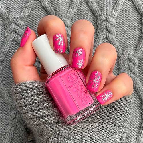 Short Hot Pink Nails That Use All Dolled Up Essie Nail Polish and Adorned with Silver jingle belle polish Snowflakes