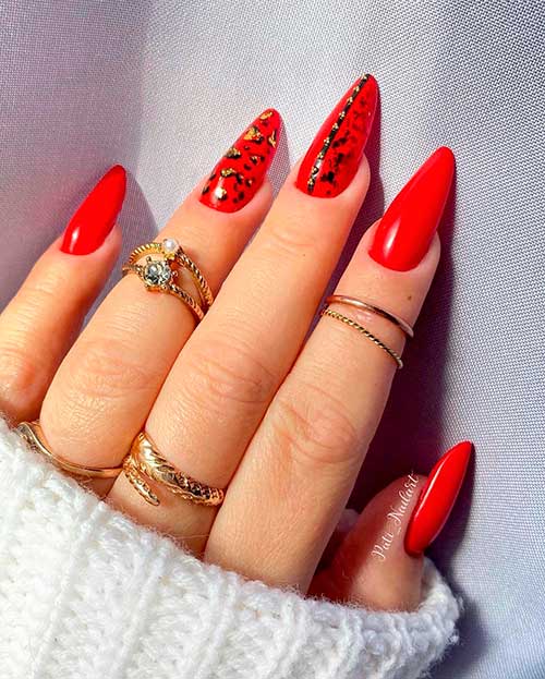 Long almond red nails with two accent animal print nails using black and gold glitter Long almond red nails with two accent animal print nails using black and gold glitter