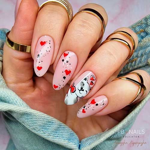 Long almond-shaped nude valentines nails 2023 with red hearts, white and black dots, a teddy bear shape