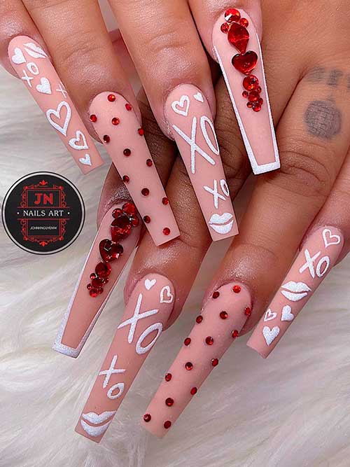 Long nude coffin valentines day nails with red rhinestones, and white love symbols