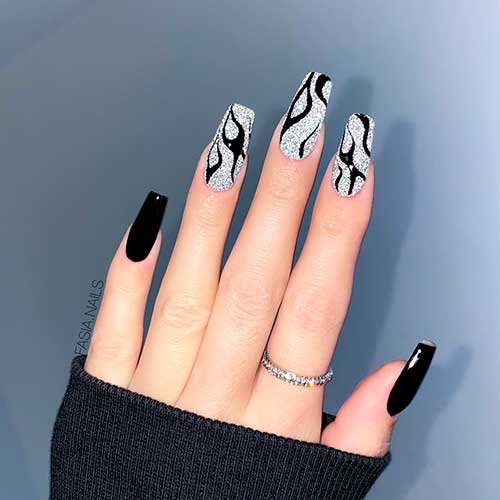 Long coffin black nails with glitter silver nails adorned with abstract black nail art