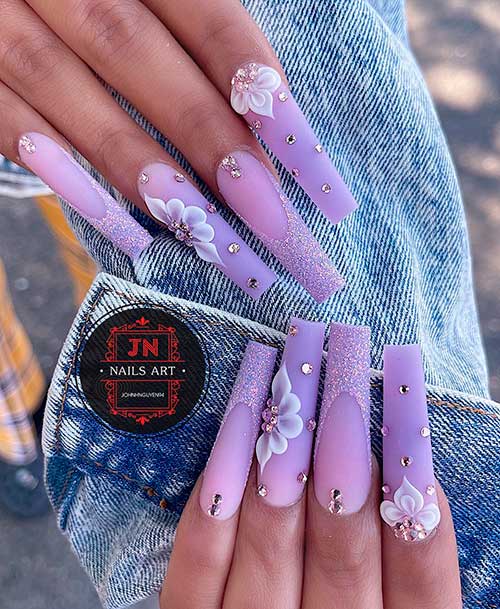 Matte lavender long spring nails with white flowers, rhinestones, and glitter