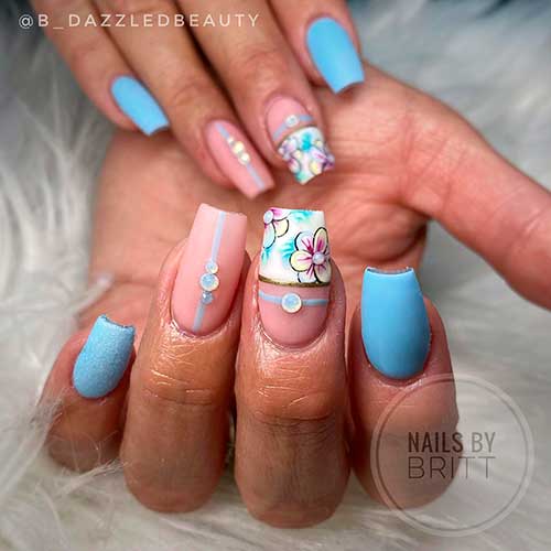 Medium coffin spring light blue nails with rhinestones on two nude accents one of them has floral nail art