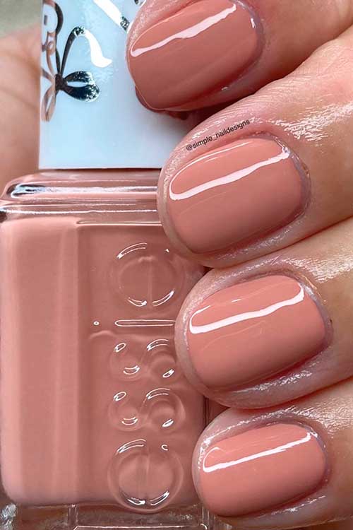 Short mid-tone nude pink nails that using Essie nail polish respond with a kiss from valentines day collection 2022