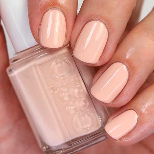Short pastel peach nails that uses Well Nested Energy Essie nail polish for spring season