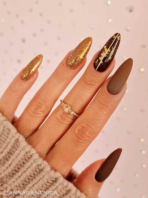 Dark matte almond brown nails with two gold glitter accent nails and gold foil on glossy brown nail