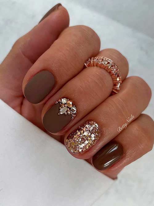 Short matte brown nails with gold glitter, rhinestones, and accent glossy brown nail 