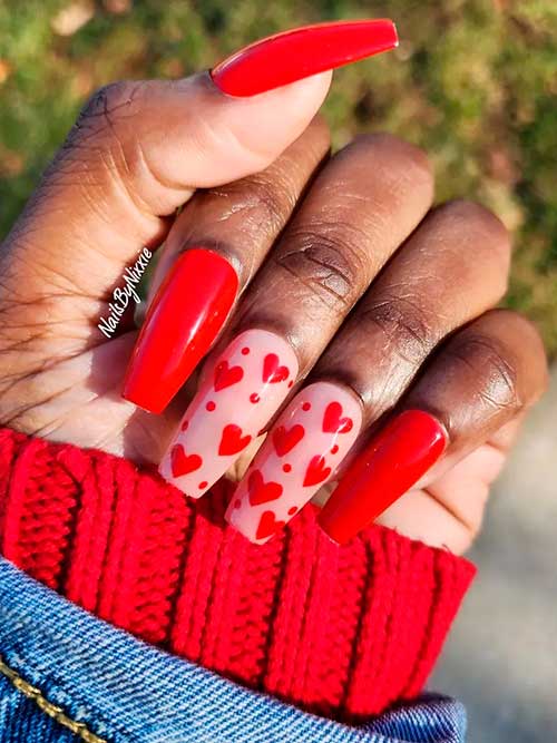 Red coffin press on valentine nails with red hearts on two nude pink accent nails