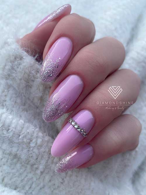 Long round shaped Lilac nails with silver glitter on nail tips and rhinestones on an accent nail