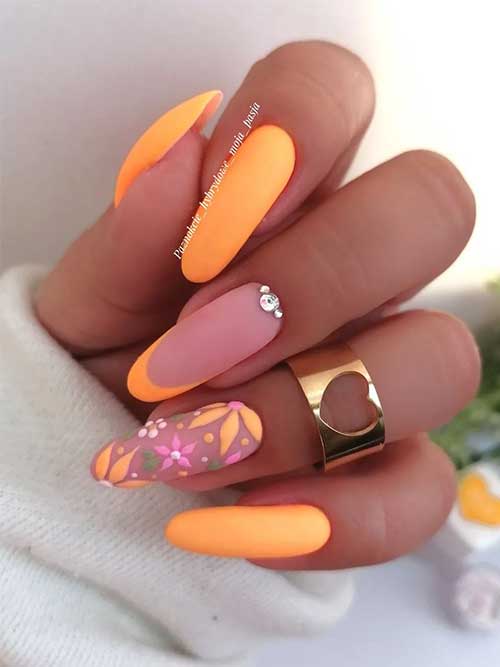 Long matte pastel neon orange nails with floral nail art and rhinestones