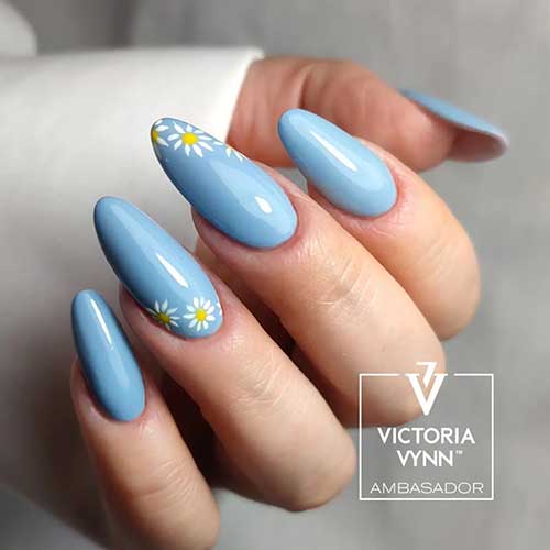 Long almond light blue nails with daisy flowers on two accent nails for spring 2023