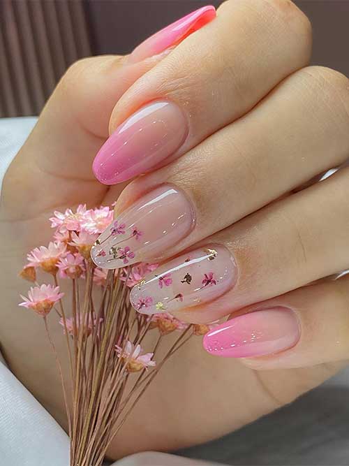 Medium almond-shaped soft and beautiful pink ombre nails with flowers and gold foil on two accent nude nails