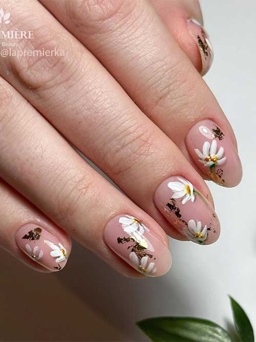Short natural round nails with daisy flowers and gold foil for spring 2023