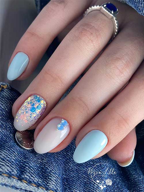Short Almond Shaped Baby Blue Nails with Glitter and Rhinestones on Accent Nude Nails