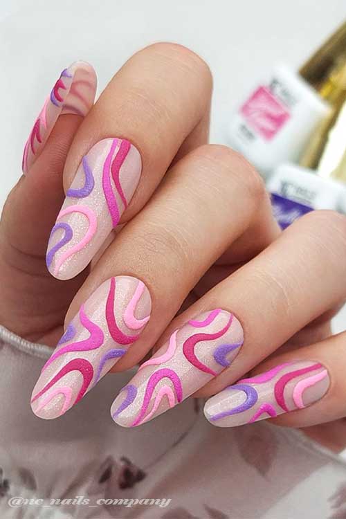 Long almond shaped glitter nude nails with different matte shades of pink and purple swirls Long almond shaped glitter nude nails with different matte shades of pink and purple swirls