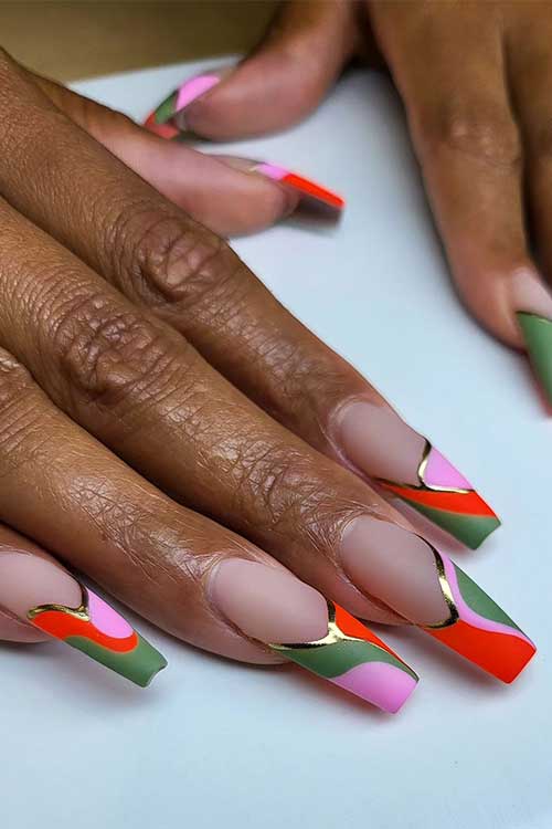 Long coffin French tip nails feature matte pink, green, neon red, and gold metallic swirl nail art