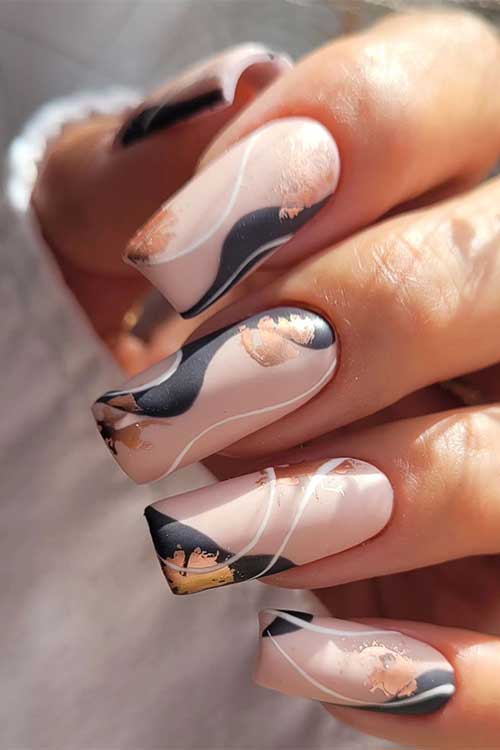 Long square shaped matte beige and black abstract autumn nails with gold foil patches and thin white swirls