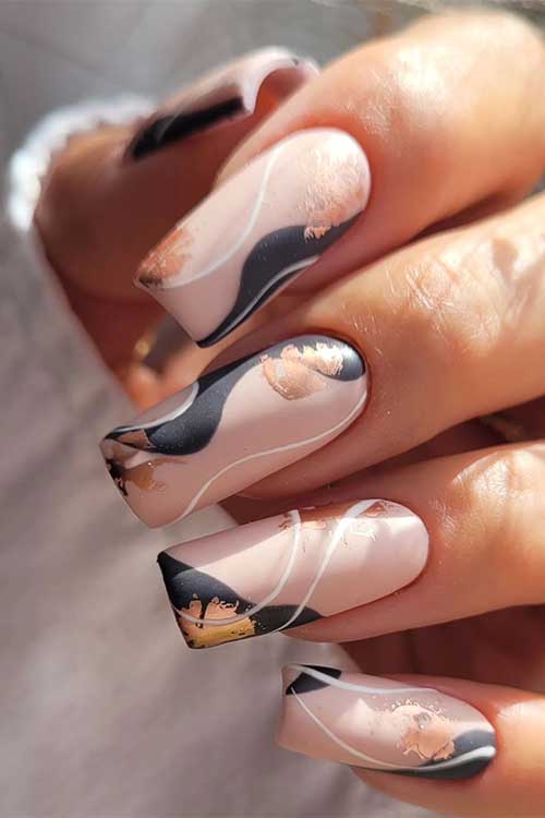 Long square shaped matte beige and black abstract autumn nails with gold foil patches and thin white swirls Long square shaped matte beige and black abstract autumn nails with gold foil patches and thin white swirls