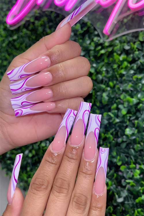 Long square shaped white French tip nails with lilac and purple swirls