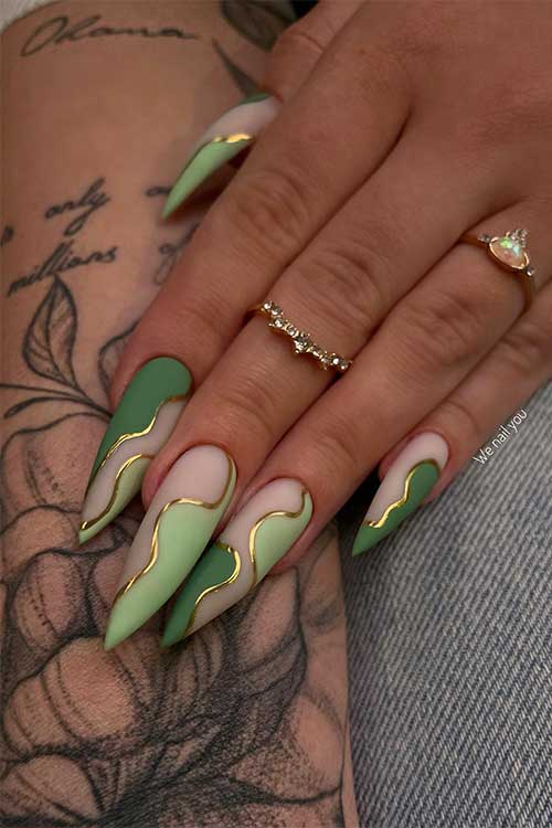 Long stiletto dark and light green negative space nails with gold swirls