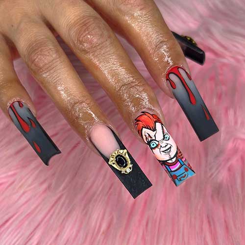 Black French ombre Halloween nails with blood drip nail art, Chucky face on an accent nail, and gold rhinestones