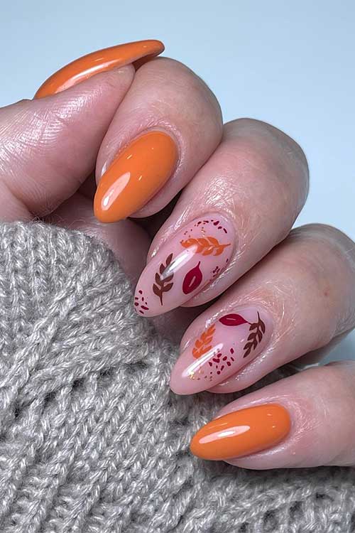 Medium Almond Shaped Burnt Orange Nails with Autumn Leaves on Two Nude Accent Nails